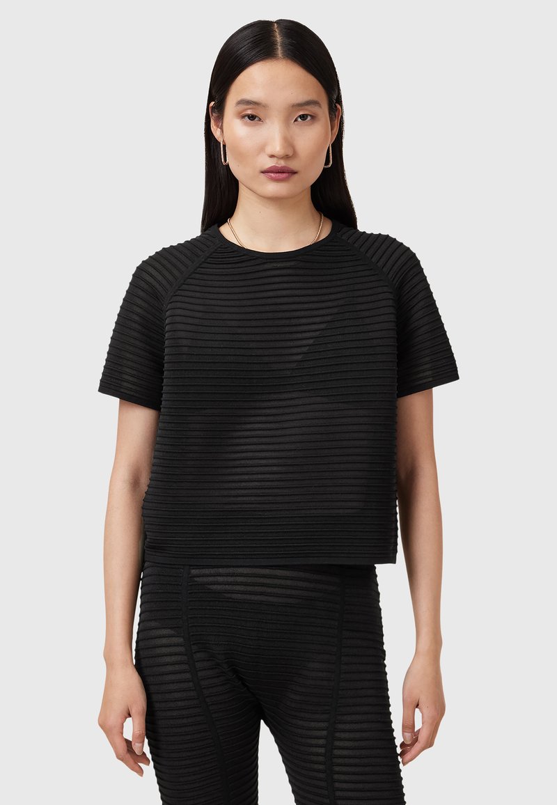 Zwarte cropped top met een geribbelde textuur, korte mouwen en een ronde halslijn. Gecombineerd met een bijpassende geribbelde onderkant.