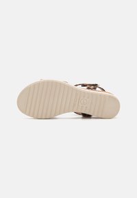 Brown leopard print sandal with a soft footbed, adjustable strap, and a textured beige rubber sole featuring horizontal grooves.