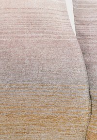 Kötött anyag ombre mintával, amely világos rózsaszínről aranysárgára vált, puha tapintással és finom vízszintes vonalakkal.