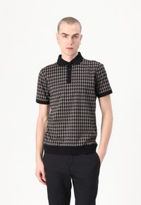 Mustan ja beeži lühikeste varrukatega polo särgil on harkpitsmustrit, must kaelus ja mansetid ning kitsas lõige.