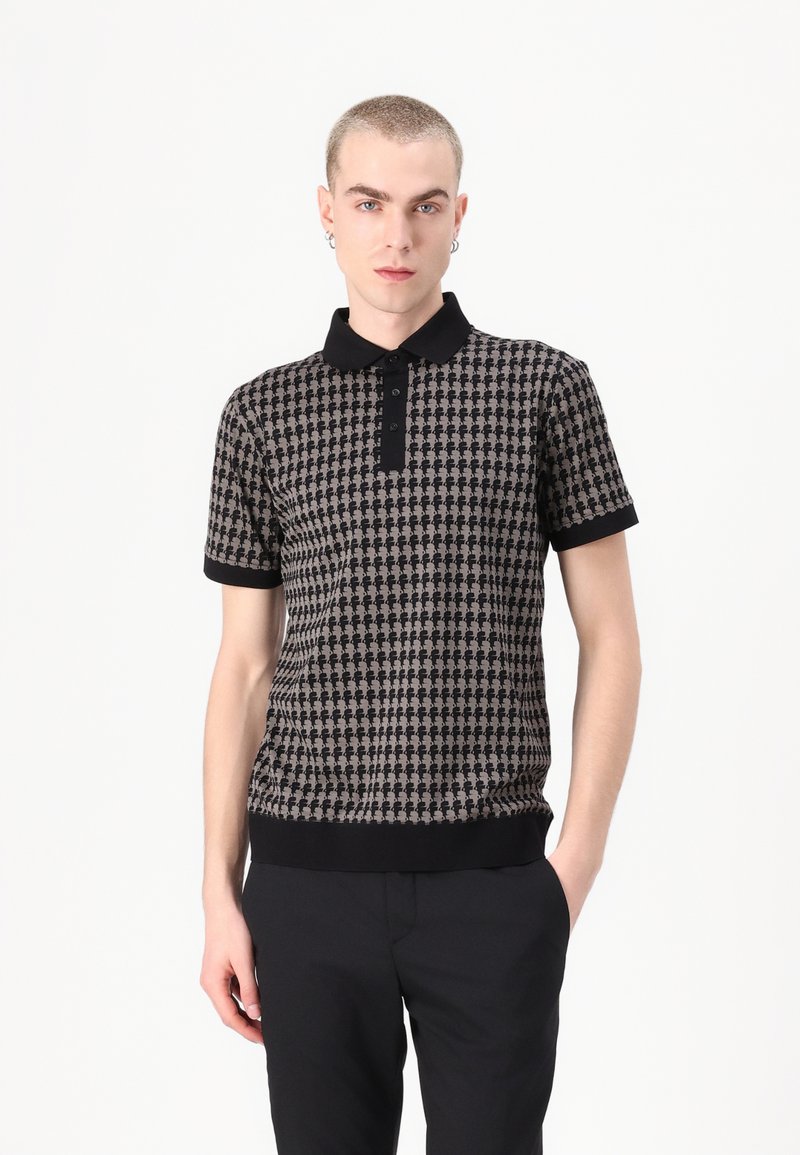 Mustan ja beeži lühikeste varrukatega polo särgil on harkpitsmustrit, must kaelus ja mansetid ning kitsas lõige.