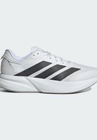 Chaussure de sport blanche avec dessus en maille, trois rayures noires, design texturé et une semelle en caoutchouc léger marquée "LIGHTSTRIKE."