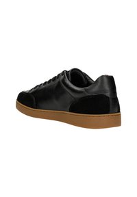 Sneaker in pelle nera con accentuazioni in camoscio, caratterizzati da una suola piatta marrone, punta arrotondata e sei occhielli. Il tallone posteriore presenta un piccolo logo.