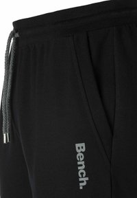 Zwarte sweatpants met een trekkoord taille, voorzien van een gestructureerde grijze koord en een grijs "Bench." logo aan de linkerkant.