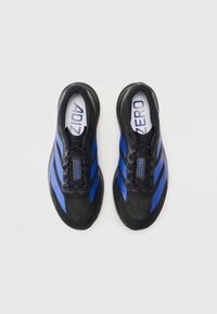 Chaussures de sport noires avec des rayures bleues, présentant une tige texturée, un bout rond et un système de laçage. Logo "ADIZERO" sur la languette.