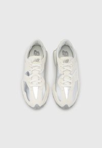 Λευκά και ασημένια αθλητικά παπούτσια χωρίς σήμανση, με επάνω μέρος από δίχτυ, ανακλαστικές λεπτομέρειες και υφασμένο πάτο. Περιλαμβάνονται κορδόνια και επενδυμένος γιακάς.