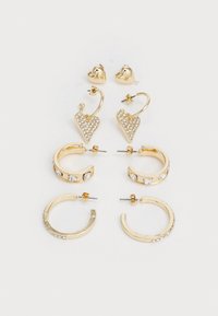 Set aus vier Paar goldenen Ohrringen: herzförmig mit Strasssteinen, runde Creolen, schlichte Creolen mit Akzenten und strukturierten Designelementen.
