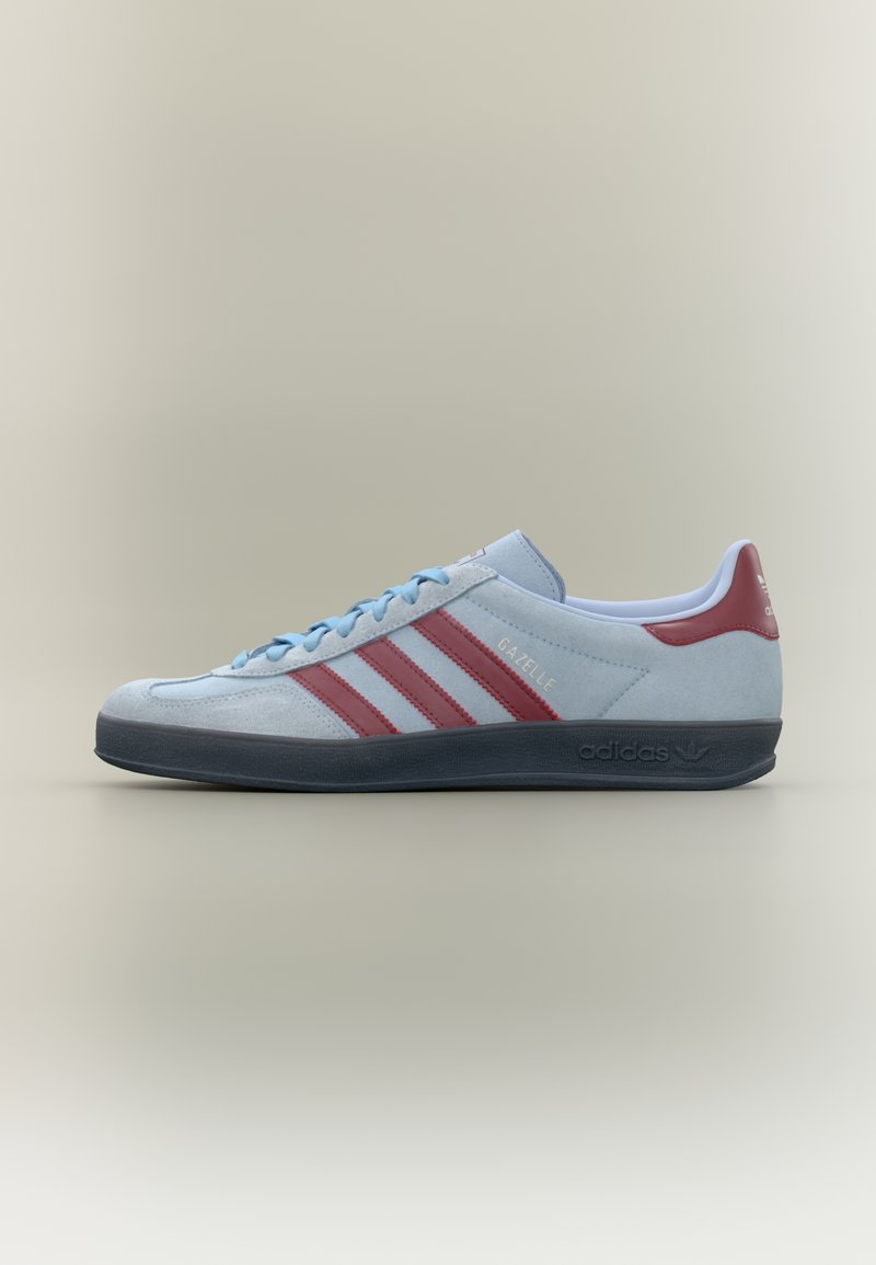 Jasnoniebieski sneaker Adidas Gazelle z bordowymi paskami, jasnoniebieskimi sznurówkami i czarną podeszwą na neutralnym tle.