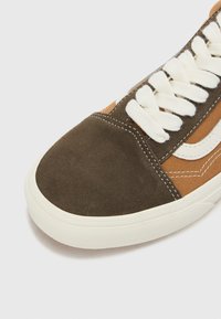 Sneaker din suede maro și canavaz bej, cu șireturi și accente albe. Vârf rotund, cu talpă din cauciuc și detalii de cusătură în contrast.