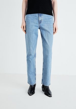 Jeans dritti di colore azzurro chiaro realizzati in denim con un classico design a cinque tasche. Indossati con stivali neri alla caviglia con punta quadrata.