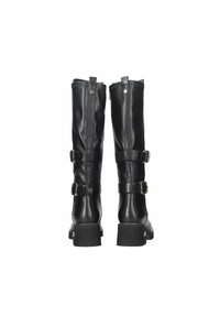 Botas de cuero negro hasta la rodilla con dos correas decorativas y hebillas, punta redonda y tacones robustos. Textura suave y detalles de costura.