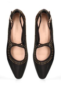 Scarpe in pelle nera con punta affusolata, lati tagliati e borchie dorate attorno alle aperture. Presentano una chiusura con cerniera sul retro.
