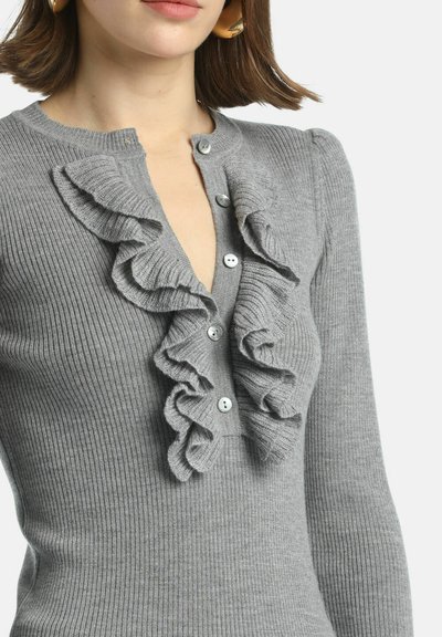 Gray ribbed knit top featuring a button closure and a ruffled front design. Long sleeves and soft texture enhance visual appeal.