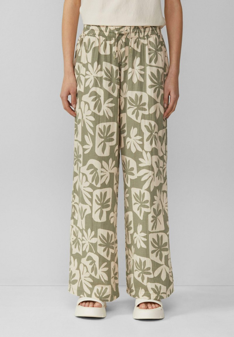 Lossere, lichtbeige broek met groene botanische patronen, voorzien van een elastische tailleband en wijdere pijpen. Zachte, gestructureerde stof.
