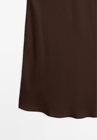 Spodní část hladké, tmavě hnědé látkové sukně s mírně zaobleným lemem na bílém pozadí.