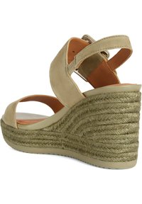 Sandalia con cuña de ante beige, con un tacón de yute trenzado, parte trasera abierta y doble tira; cuenta con una suela texturizada para mayor agarre.