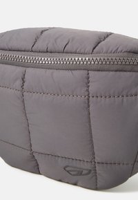 Borse cosmetica grigia trapuntata con chiusura a zip, realizzata in tessuto morbido, con una accentuazione del logo e un robusto dettaglio della zip.