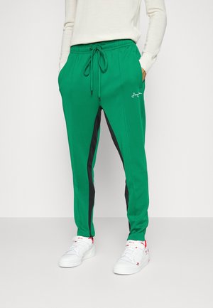 Zielone spodnie do joggingu z czarnymi paskami po bokach. Wykonane z miękkiego materiału, posiadają elastyczny pas z sznurkiem oraz boczne kieszenie.