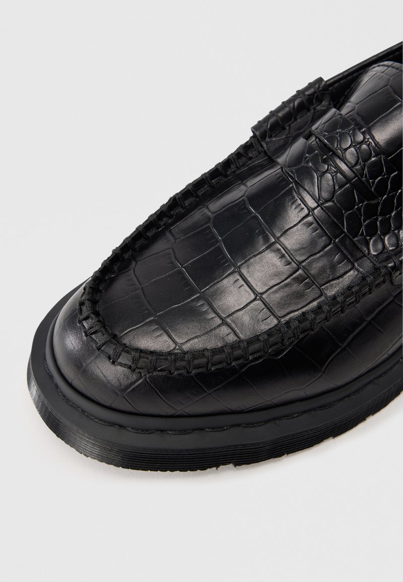 Schwarze Leder-Läuferschuhe mit einem strukturierten Krokodil-Muster, gestickten Details an den Rändern und einer abgerundeten Zehenpartie mit einer Gummisohle.