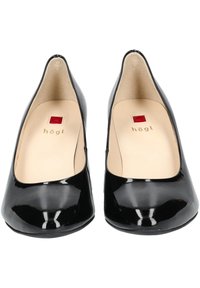Scarpe con tacco alto in vernice nera con punta arrotondata e superficie liscia. Soletta color crema con accenti rossi e logo del marchio.