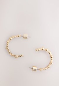 Gold-colored hoop earrings with a textured design featuring small spherical accents. They have a secure post closure.