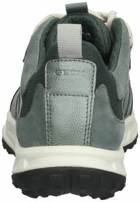 Zapato gris que combina materiales de cuero y malla, con un contrafuerte de talón texturizado, suela de goma negra y una lengüeta en la parte posterior.