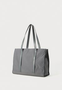 Sac fourre-tout rectangulaire gris avec des longues poignées et un tissu texturé sur un fond blanc.