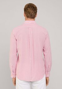 Rot-weißer, gestreifter Langarmshirt mit Button-Down-Kragen und Rückfalte. Mit Knopfmanschetten und abgerundetem Saum.