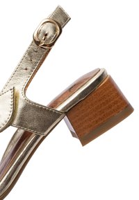 Sandale en cuir doré avec bride à la cheville et boucle dorée, avec un talon bloc marron épais.