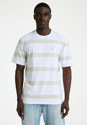 Camiseta de manga corta con cuello redondo en blanco con rayas horizontales beige. Tiene un pequeño logo en el pecho izquierdo y un corte relajado.