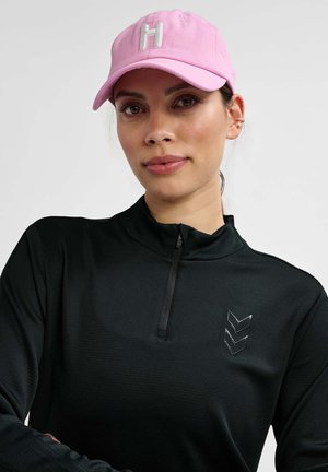 Casquette de baseball rose avec un brodé blanc en forme de "H" ; haut zippé noir avec un motif texturé subtil et un détail en chevron réfléchissant sur la poitrine.