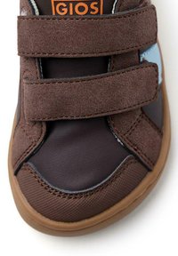 Sneaker in suede marrone con due fasce in Velcro, suola in gomma e dettagli azzurri sul lato. Superfici lisce e testurizzate.