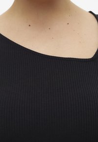 Top nero a costine con scollatura asimmetrica, realizzato in tessuto elasticizzato in cotone misto, caratterizzato da una superficie liscia e dettagli sottili.