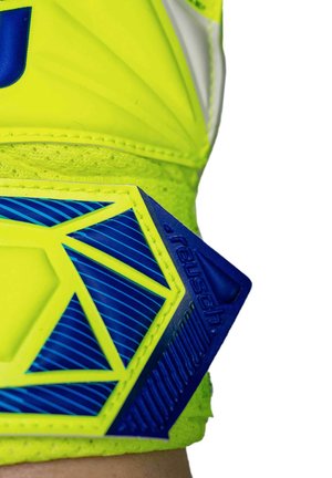 Close-up of neon yellow and blue wrist strap with geometric pattern and "Reusch" brand name on a sports glove.