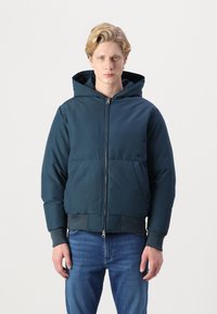 Chaqueta puffer con capucha en verde azulado oscuro, que presenta un cierre de cremallera en la parte frontal, puños y dobladillo acanalados, con una textura acolchada y dos bolsillos frontales.