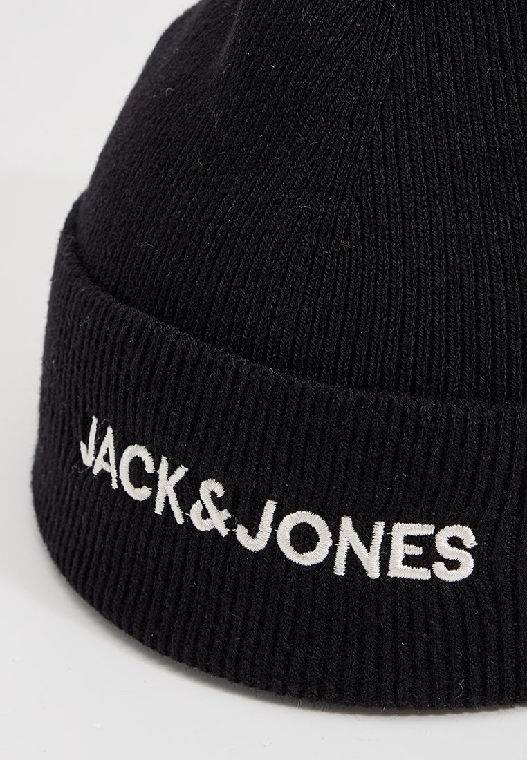 Zwarte gebreide muts gemaakt van textiel met een geribde structuur; heeft een witte geborduurde "JACK&JONES" logo aan de voorkant.
