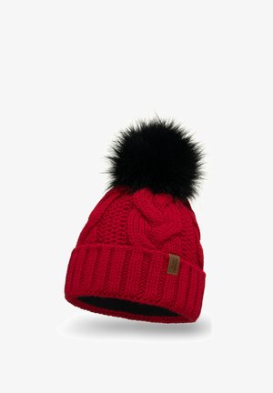 Red knitted hat with a textured cable pattern, featuring a black faux fur pom-pom on top and a brown leather patch on the cuff.