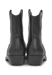 Stivaletti neri in pelle con finitura liscia, punta rotonda, tacco basso e inserti elastici per una facile calzata. Le cuciture sono sottilmente visibili.