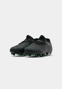 Black and dark green soccer cleats with laces, textured surface, and studded soles, positioned front-facing on a white background.
