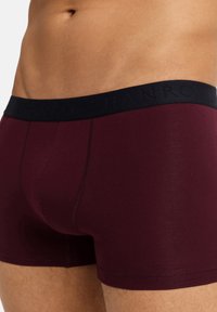 Bordó bavlněné boxerky s tmavě modrým pasem s raženým logem. Hladká textury a přiléhavý střih zvyšují pohodlí.