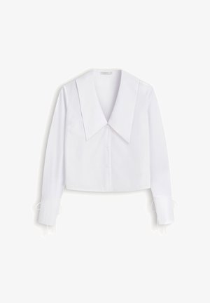 Biała bluzka z guzikami, z dużym, spiczastym kołnierzem, długimi rękawami i detalami w postaci związania na mankietach, wyeksponowana na jednolitym tle.