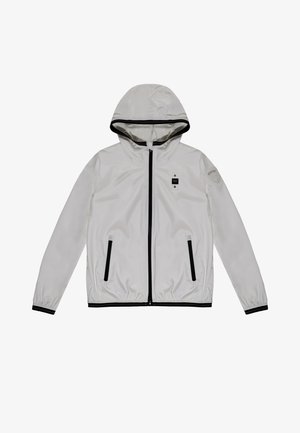 Giacca bianca con cappuccio realizzata in tessuto lucido, con zipper frontale, dettagli neri e due tasche laterali. Il design è semplice e funzionale.
