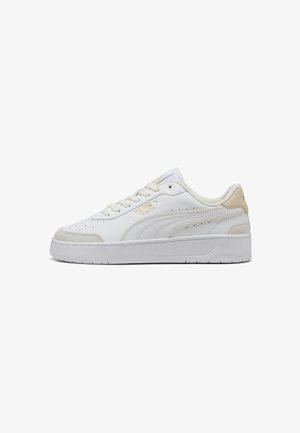 White sneaker with a smooth leather upper, textured accents, narrow perforations, raised sole, and subtle beige heel detailing.