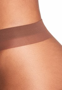Fascia marrone senza cuciture su materiale color pelle, con una texture liscia e una leggera lucentezza. Dettaglio ravvicinato del tessuto.