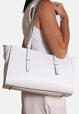Witte leren tote bag met een gestructureerd oppervlak, voorzien van contrasterende zwarte stiksels, twee schouderbanden en gouden hardware accenten.