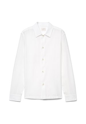 Chemise blanche à manches longues avec boutons, col classique et texture subtile à rayures verticales, présentée sur un fond uni.