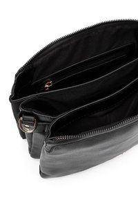 Bolso de cuero negro con tres compartimentos. Presenta cierres de cremallera, bolsillos interiores y un acabado texturizado. Diseño minimalista con herrajes en tono dorado.