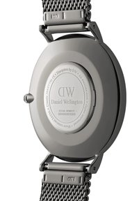 Silver stainless steel watch back with engravings, featuring a round shape, a mesh band, and a polished finish. Serial number included.
