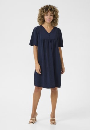 Marineblaues Kleid mit kurzen Puffärmeln, V-Ausschnitt und Knopfdetails. Hergestellt aus strukturiertem Stoff mit einer lockeren, A-Linien-Silhouette.