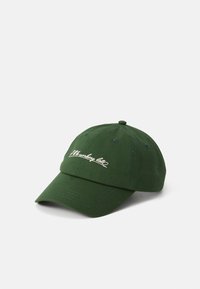 Grønn caps med en brodert hvit logo på fronten, vinklet for å vise skynderen og detaljene mot en hvit bakgrunn.